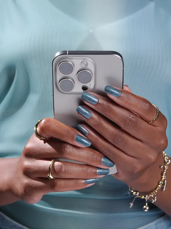 woman in blue shirt browsing news on smartphone